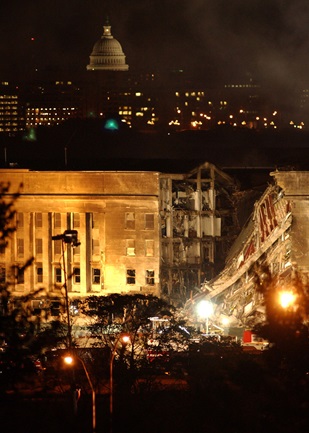 Image of smoke and flames rose over the Pentagon late into the night, following a suspected terrorist crash of a commercial airliner into the southwest corner of the Pentagon. Part of the building has collapsed meanwhile firefighters continue to battle the flames and look for survivors. An exact number of casualties is unknown. The building was evacuated, as were the federal buildings in the Capitol area, including the White House. (U.S. Navy photo by Photographer’s Mate 2nd Class Bob Houlihan).