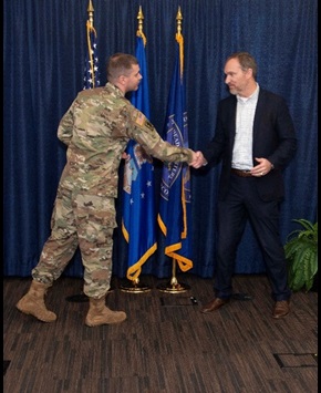 Army Lt. Col. Kevin Sturm, commander of the DISA Army Reserve Element, presents Joe Wassel, head of DISA’s Cyberspace Operations Directorate, with the first of ARE’s newest coin during the unit’s drill weekend at agency headquarters March 4. (Photo by Eric Glisson)