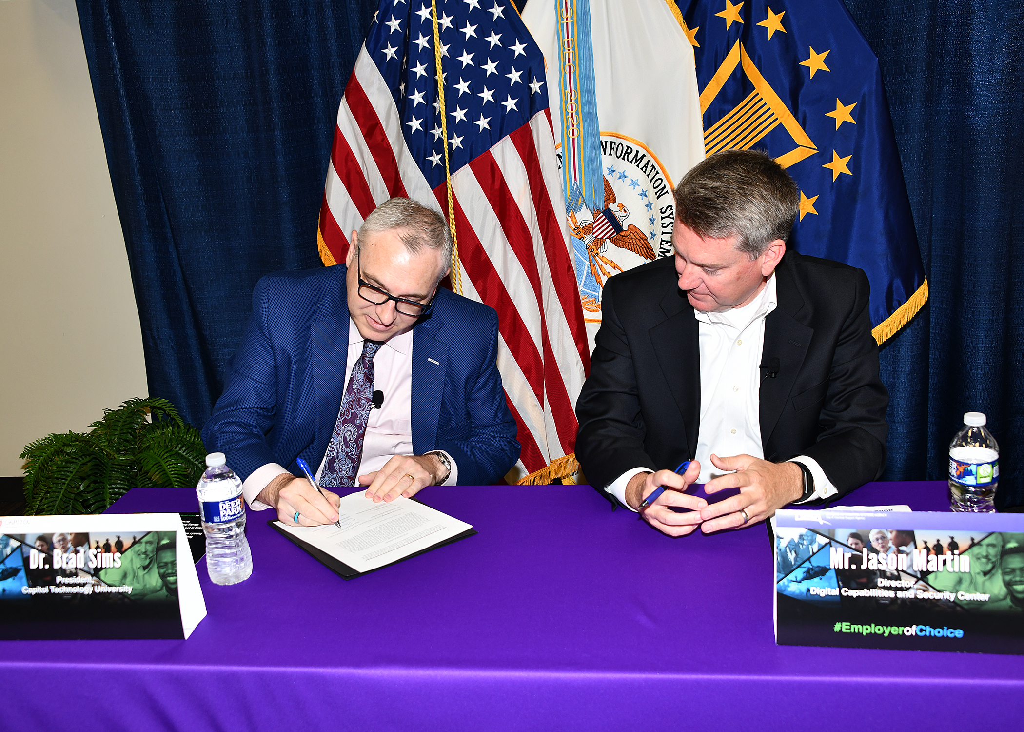 President, Capitol Technology University, Dr. Brad Sims, left, shakes hands with DISA Digital Capabilities and Security Center Director and Acquisition Executive, Jason Martin, during Education Partnership Agreement signing ceremony June 24 at Fort George G. Meade. (U.S. DOD photo by Thomas L. Burton, DISA/Released).