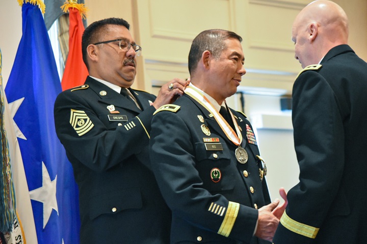 Army Command Sgt. Maj. Michael Cresopo and Lt. Gen. John Morrison present Army Major Gen. Garrett Yee with the Silver Order of Mercury