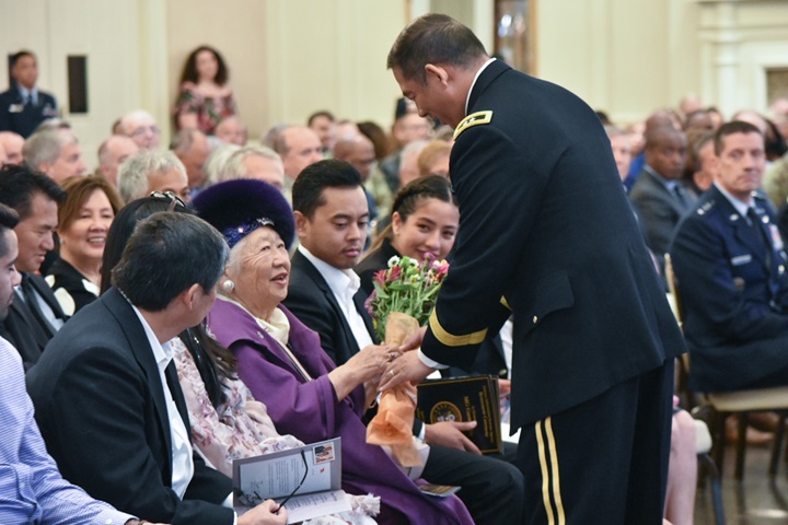 Major Gen. Garrett Yee presents his mom, Michiko Yee, flowers during his retirement ceremony