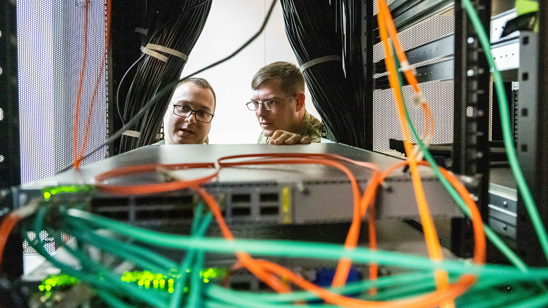 Two personnel observe a server room